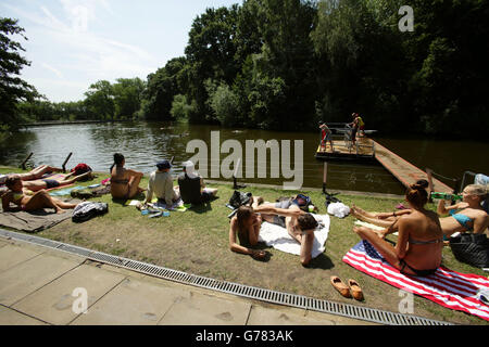 La gente toma el sol en los estanques mixtos de Hampstead Heath, Londres, durante un período de tiempo caluroso. Foto de stock