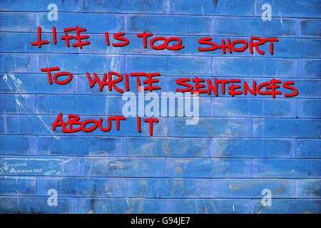 "La vida es demasiado corta para escribir oraciones sobre ella" escrito sobre una pared azul Foto de stock