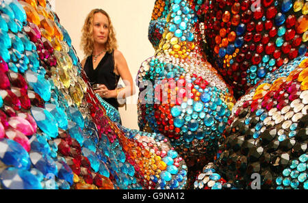 Una mujer observa la escultura del artista Tony Heywood llamada 'Shimmer' en la Fine Art Society de Londres, hecha de 150.000 joyas y basada en la forma de microorganismos. Foto de stock