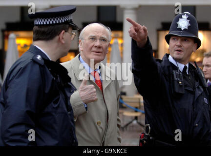 El líder demócrata liberal Menzies Campbell camina el golpe con dos oficiales de la policía metropolitana en Covent Garden de Londres antes de hacer un discurso sobre sus cinco maneras de cortar el crimen. Foto de stock