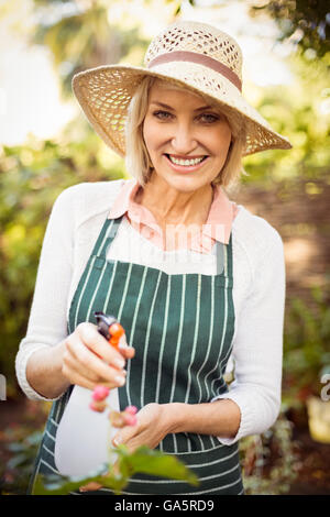 Mujer sonriente mientras que regar las plantas