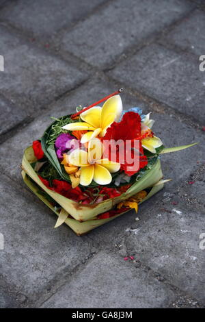 Canang sari, tradicional de Bali, ofrendas a los dioses en Bali con flores aromáticas y palos Foto de stock