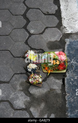 Canang sari, tradicional de Bali, ofrendas a los dioses en Bali con flores aromáticas y palos Foto de stock