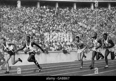 Jesse Owens (segundo r) de EE.UU. Se ralentiza después de entregar el bastón al compañero de equipo Ralph Metcalfe (r) para la última etapa. El equipo estadounidense estableció un nuevo récord mundial de 39,8 segundos Foto de stock