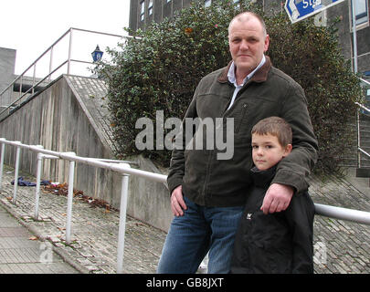 Mark Frearson y su hijo Harry fuera de la estación de policía de Charles Cross, Plymouth. El Sr. Frearson fue arrestado y encerrado en una celda durante la noche por aplastar la pierna de su hijo. Foto de stock