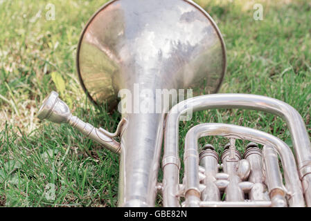 Parte de plata trombón en th hierba, Cerrar imagen arriba Foto de stock