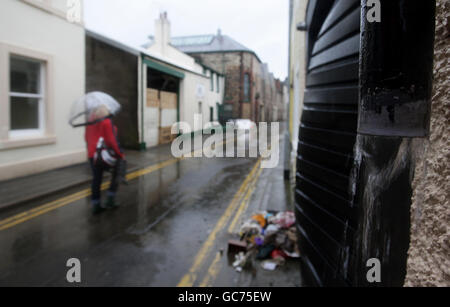 Una mujer camina por el centro de Cockermouth tras las recientes inundaciones. Foto de stock