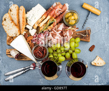 Queso y carne de aperitivo o snack de selección establecidos para el vino. Prosciutto di Parma, salami, palos de pan, rodajas de pan baguette, aceitunas, s Foto de stock