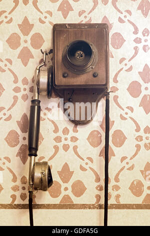 Teléfono antiguo con manivela se cuelga en la pared de decoración Foto de stock