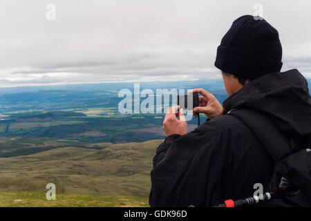 Hombre tomar la fotografía de paisaje de Ben Wyvis mirando por encima de dingwall y strathpeffer