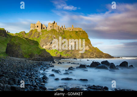 Amanecer sobre Castillo de Dunluce a lo largo de la costa norte del Condado de Antrim, Irlanda del Norte, REINO UNIDO