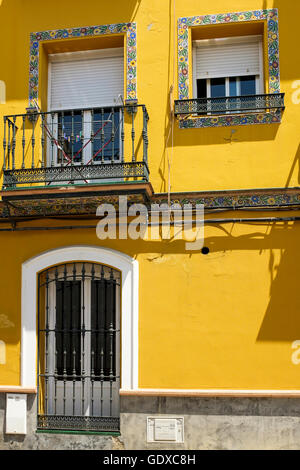 Pintado de amarillo brillante edificio residencial, con decoración de  azulejos, en el barrio de Triana de Sevilla, España Fotografía de stock -  Alamy
