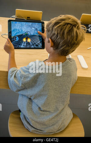 Un niño 7-8 años juega un partido en un iPad en el Apple Store en Santa Bárbara, California. Foto de stock