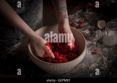 Día de San Valentín para hornear, mujer preparando frambuesas frescas en un recipiente.