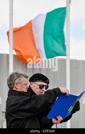 Un hombre vestido con uniforme paramilitar republicano irlandés INLA lee desde el rollo de honor durante la Pascua, el aumento anual de conmemoración en el cementerio de Milltown, Belfast, Irlanda del Norte. Foto de stock
