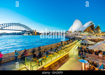 La gente cenando en restaurantes al aire libre en Circular Quay en Sydney, Australia