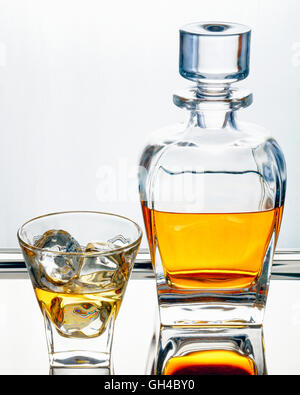 Buen Whisky escocés tradicional en decantador y cristal con cubitos de hielo.