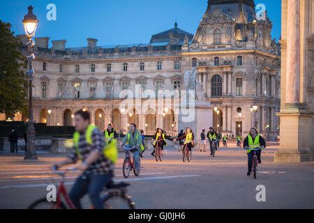 Un tour en bicicleta grupo pase el Arc de triomphe du Carrousel & Palais du Louvre al atardecer, París, Francia
