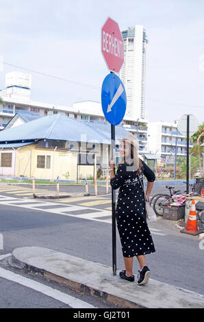 Viajero mujer tailandesa retrato en señal de tráfico en la carretera de George Town y área de arte en la calle el 26 de abril de 2016 en Penang, malayos Foto de stock