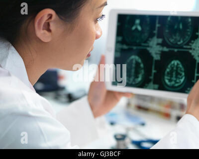 Doctor ver Tomografía computarizada del cerebro como resultado de tableta digital para detectar anormalidades Foto de stock