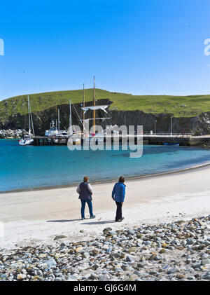 dh NORTH HAVEN FAIR ISLE Turismo mujeres caminando playa de arena barcos alta barcos yates muelle escocia islas personas