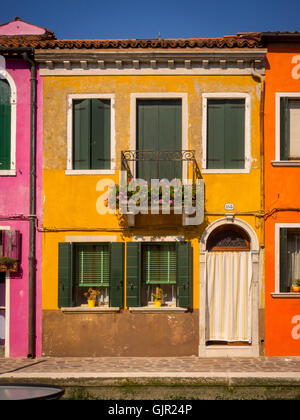La casa tradicional pintada de colores, al lado del canal en la isla de Burano. Venecia, Italia.