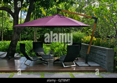 Muebles de exterior con sombrilla en el jardín Foto de stock