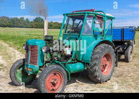 Antiguo tractor remolque de superficie plana en la granja, paisaje rural República Checa Farmer en el tractor Zetor Foto de stock
