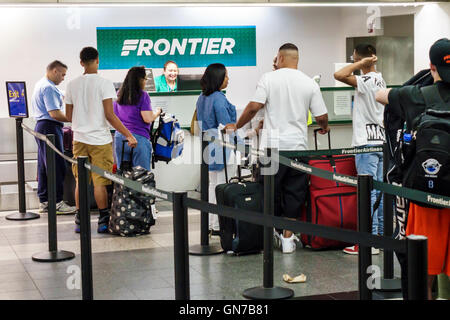 New York City,NY NYC,Queens,LaGuardia Airport,LGA,aeropuerto  nacional,terminal,Frontier Airlines,aerolínea de bajo  costo,mostrador,agente,trabajo,check-in,blac Fotografía de stock - Alamy