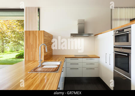 Nueva Cocina Doméstica Moderna Con Mesa De Madera Y Estufa Con Paneles  Sobre Fondo De Pared De Azulejos De Cerámica. Foto de archivo - Imagen de  estante, limpio: 224823114