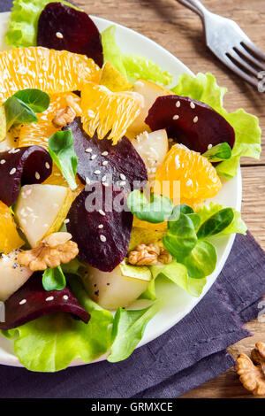 La remolacha y la naranja con ensalada de verdes, peras, nueces y semillas. Saludable comida vegetariana. Foto de stock
