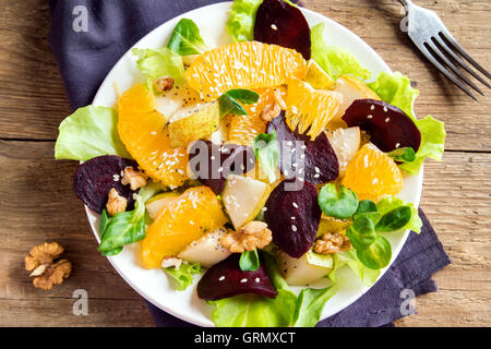 La remolacha y la naranja con ensalada de verdes, peras, nueces y semillas. Saludable comida vegetariana. Foto de stock