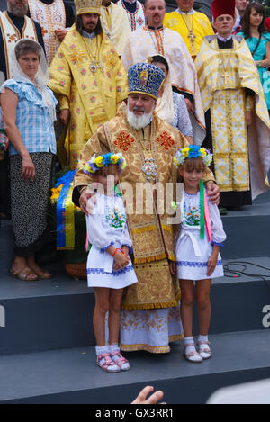 Dos niños posando con un clérigo de la Iglesia Ortodoxa de Ucrania (UOC) Patriarcado de Kiev durante una procesión. [Sólo] EDITORIAL Foto de stock