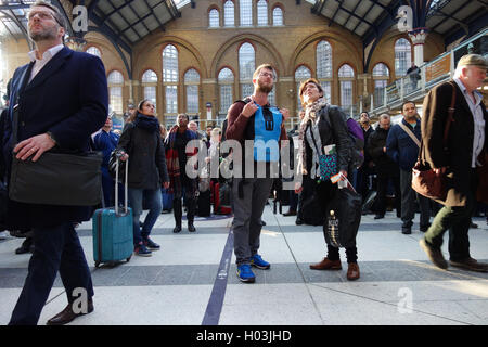Los viajeros / pasajeros mirando hacia junta de salida, esperando que retrasaron los trenes en la estación de Liverpool Street, Londres Foto de stock