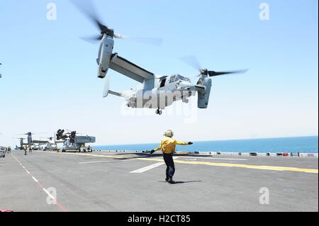Aviación Naval de Estados Unidos boatswains mate señala un U.S. Marine MV-22 Osprey assault apoyo de aeronaves en la cubierta de vuelo del USN de asalto anfibio de clase Wasp buque USS Boxer 11 de julio de 2016 en el Golfo Arábigo.