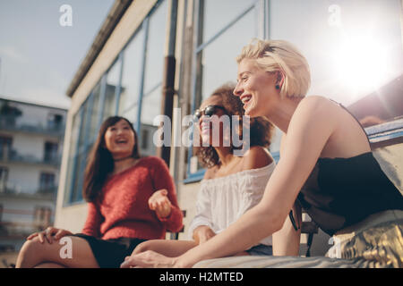 Grupo de amigas divirtiéndose mientras está sentado en la cafetería al aire libre. Tres jóvenes sentados en una terraza charlando y disfrutando.