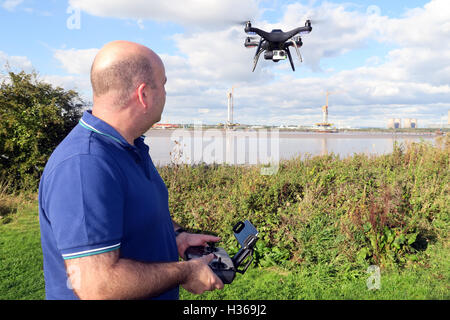 Hombre volando 3DR RTF X8 drone, cerca del río Mersey, Runcorn, Merseyside, Inglaterra, REINO UNIDO Foto de stock