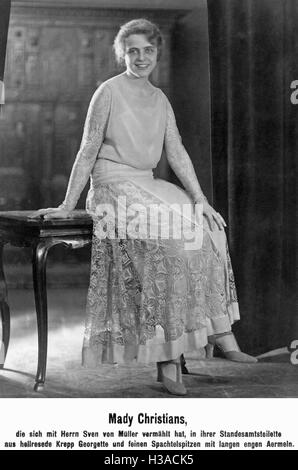 Mady Cristianos, una actriz alemana, en una chaqueta a rayas con cintura  vestido con bolsillos delanteros y flores en la cintura Fotografía de stock  - Alamy