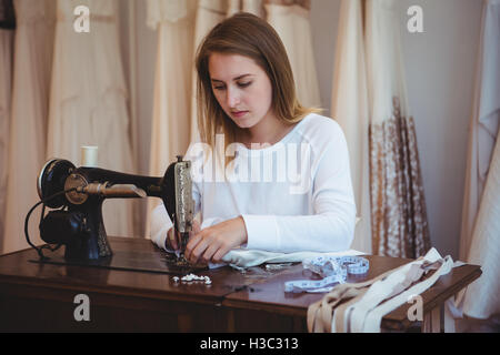 Hermosa joven mujer coser ropa con máquina de coser - Stockphoto #24213096