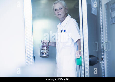 Scientist llevando rack con placas de petri en el laboratorio Foto de stock