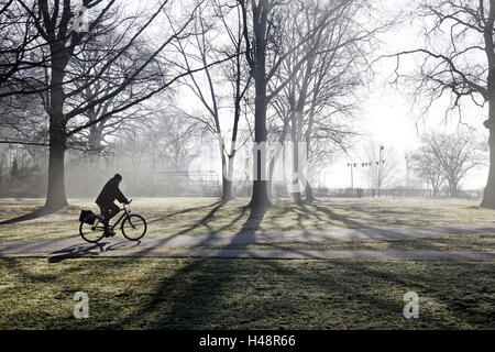 Ciclista en la niebla de la mañana temprana, Altonaer Elbberg, Balkon, Altona, Ciudad Hanseática de Hamburgo, Alemania, Foto de stock