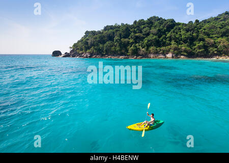 Adulto Joven divirtiéndose con kayak de mar paraíso turquesa Foto de stock