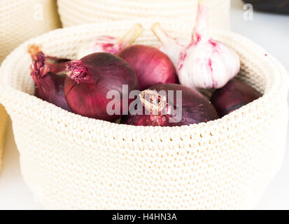 Las cebollas rojas en una cesta de mimbre de cerca Foto de stock