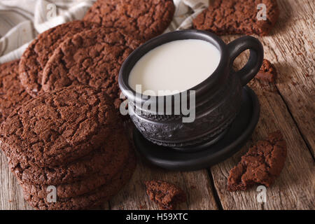 El chocolate de leche y galletas de jengibre en la mesa cercana, rústico horizontal.
