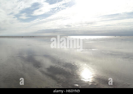 Día soleado blanco ver estratocúmulos, mirando al sur, sol blanco reflejando la arena de la playa húmeda, Fairhaven, Lytham St Annes, RU Foto de stock