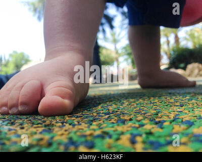 11 mes de edad Baby Boy pies sobre el piso playpark goma Foto de stock