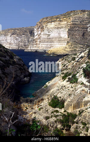Majestuosos acantilados que caen al mar en Xlendi, un pequeño pueblo en gozo Foto de stock