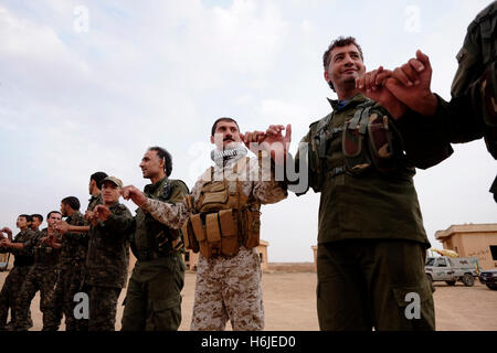 Combatientes kurdos de las Unidades de Protección Popular baile YPG Kurdo tradicional danza en una ceremonia de reclutamiento militar en Al-hasakah Hassakeh o distrito en el norte de Siria Foto de stock