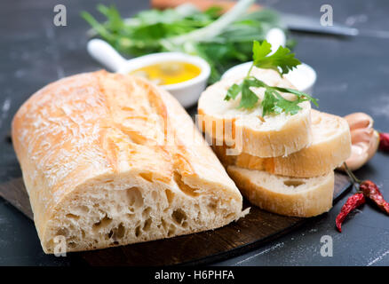 Pan fresco con sal y aceite de oliva en una tabla Foto de stock