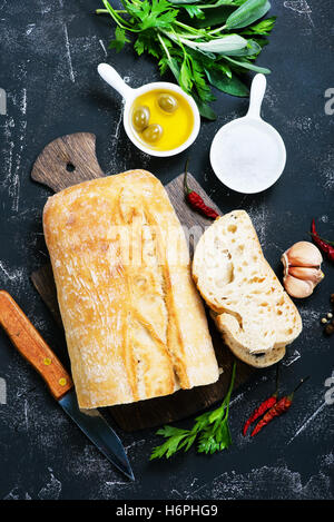 Pan fresco con sal y aceite de oliva en una tabla Foto de stock